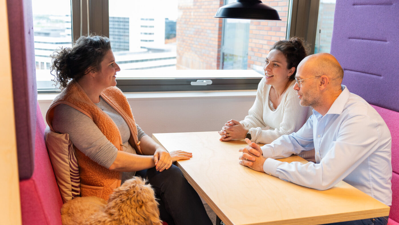 In een treincoupé op kantoor - 3 mensen met een hond