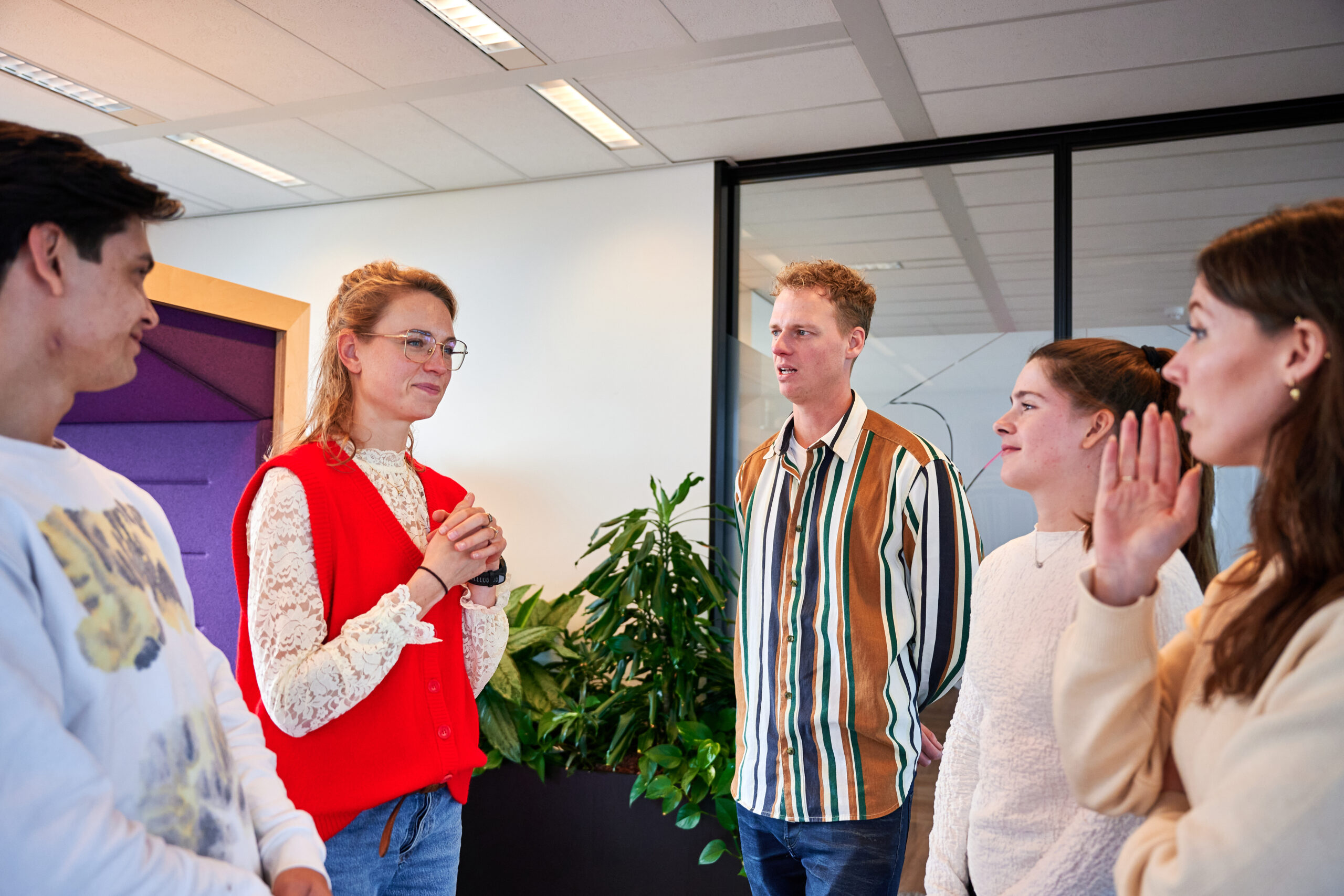 Collega's op kantoor – grote groep mensen zijn druk in gesprek met elkaar – gespannen gezichten (zelfde context als eerste foto)>