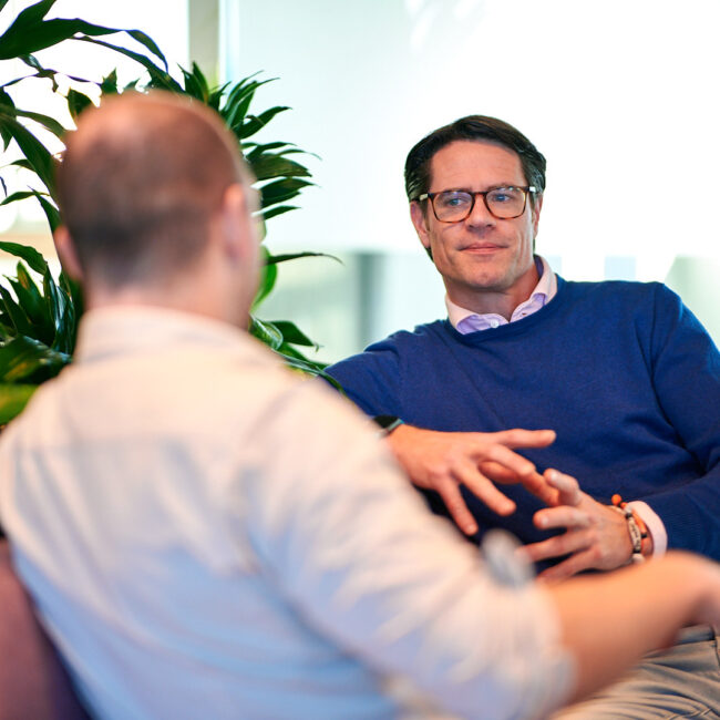 Projectmanager Koen, in gesprek met een adviseur projectbeheersing