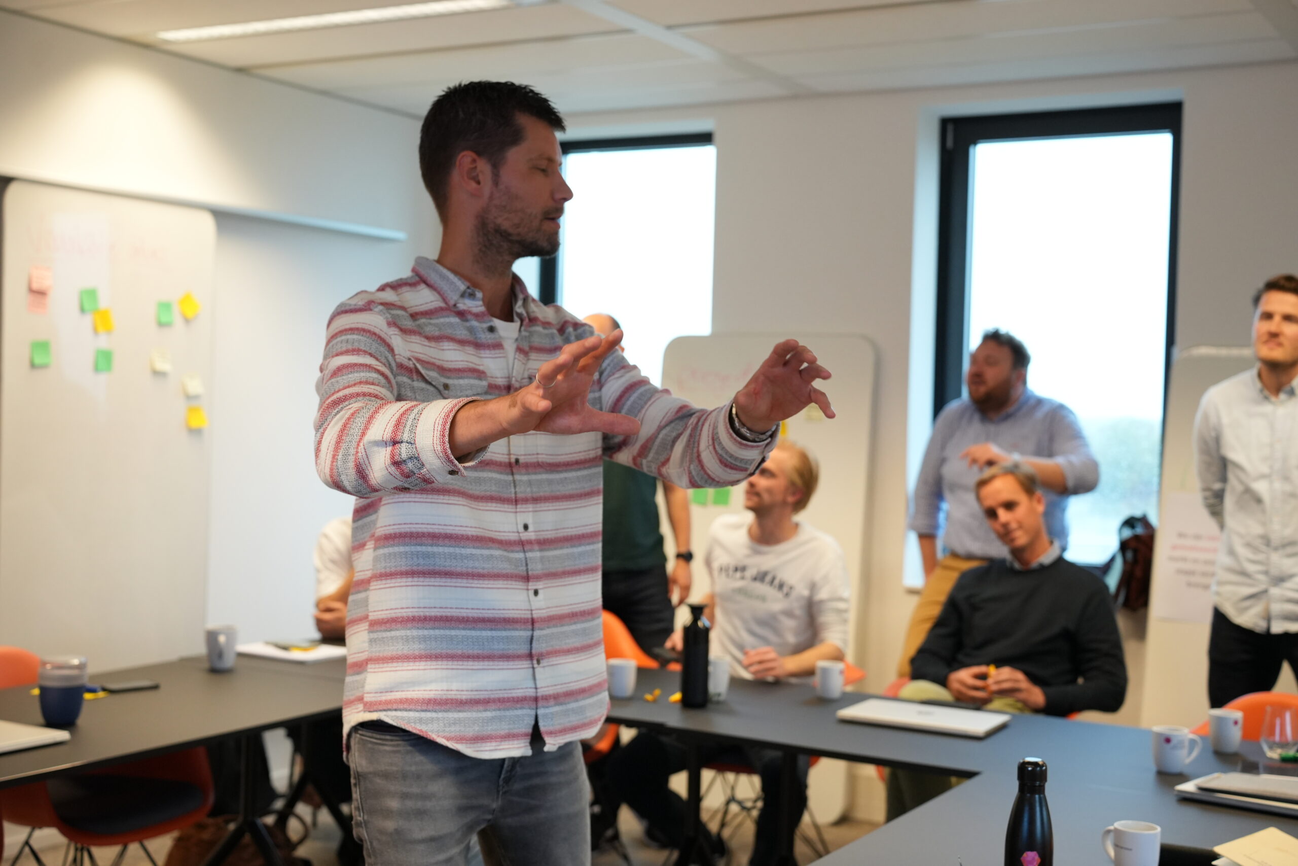 Jesse staat voor een groep iets uit te leggen met zijn handen